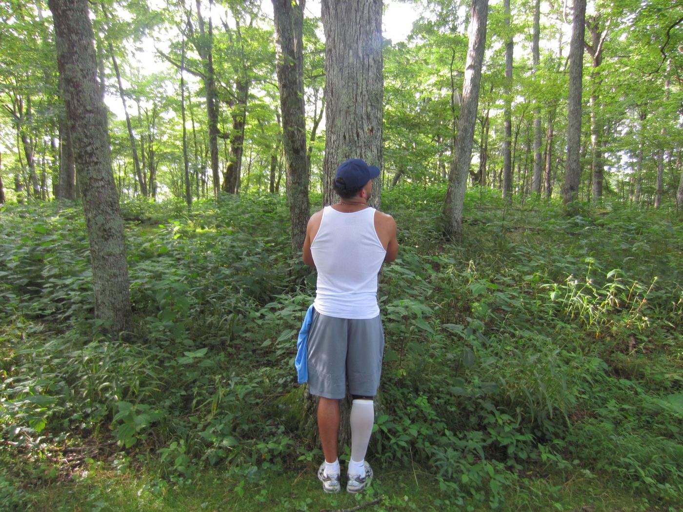 Pryce hugging a tree in the forest
