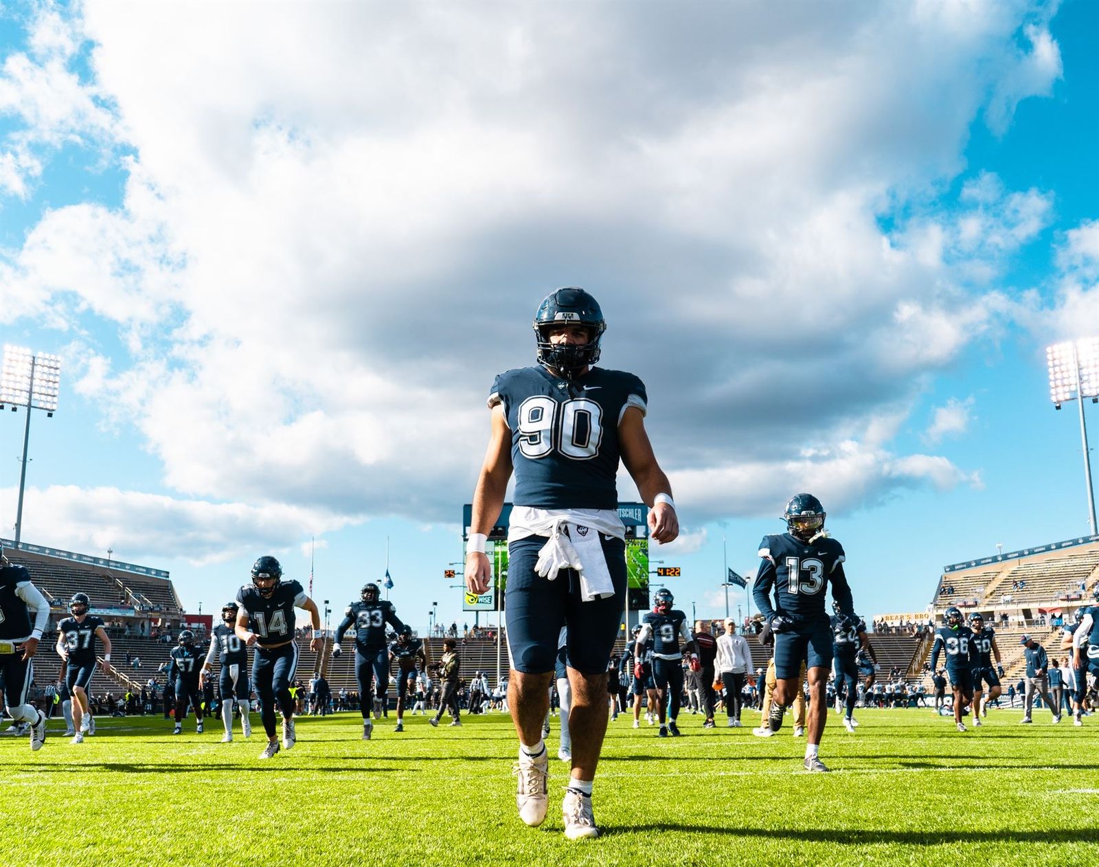 Pryce Yates in UConn's #90 jersey walking onto the field before a game